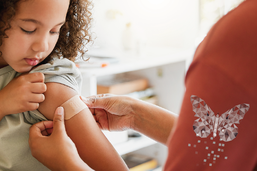 A young child receives a bandage on her arm after getting a vaccination.