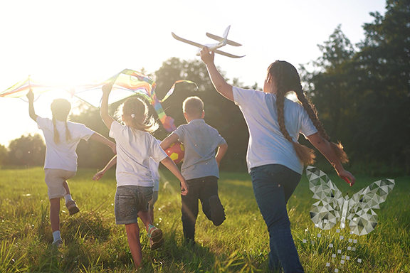 Group of kids playing. Includes the blog logo, which is a butterfly.