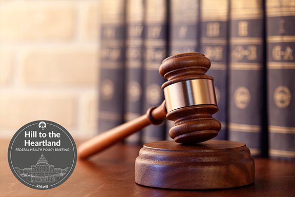 A gavel sits in front of a group of law books.